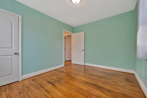 an empty room with wooden floor and closet