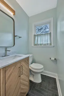 a bathroom with a sink a toilet and mirror