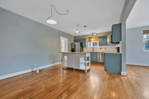 a living room with kitchen island furniture and a wooden floor