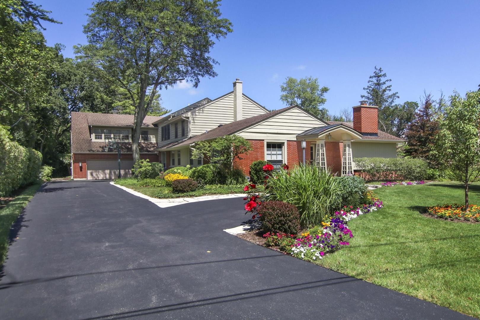 a front view of a house with a yard and a garden