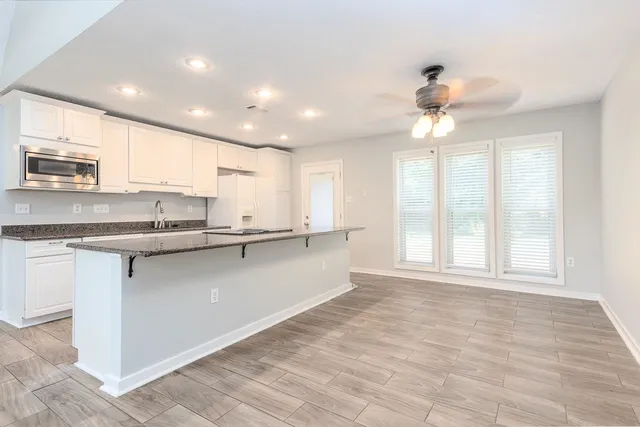 a large kitchen with kitchen island granite countertop a large window and a sink