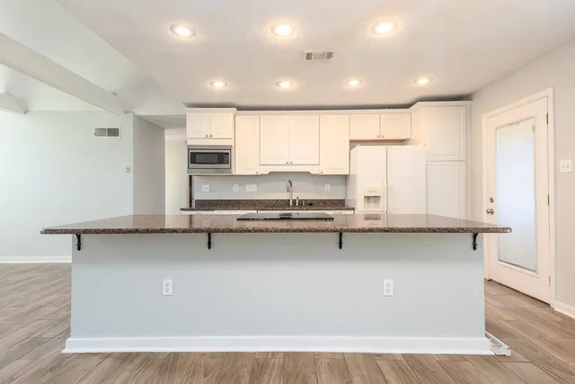 a kitchen with stainless steel appliances granite countertop a stove a sink and a refrigerator