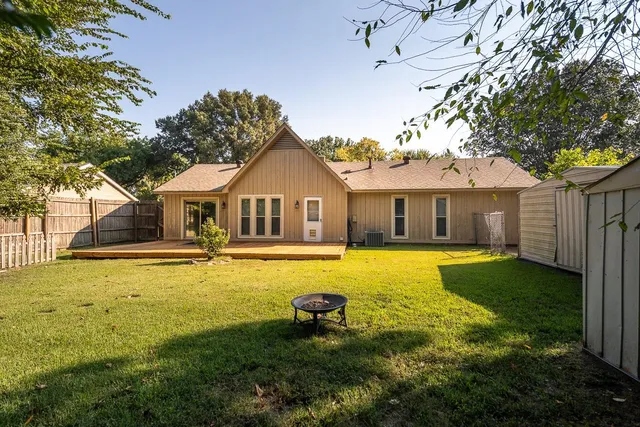 a backyard of a house with lots of green space and wooden fence