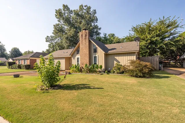 a front view of a house with yard and lake view