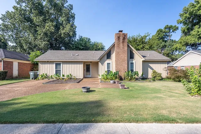 a front view of a house with yard and green space