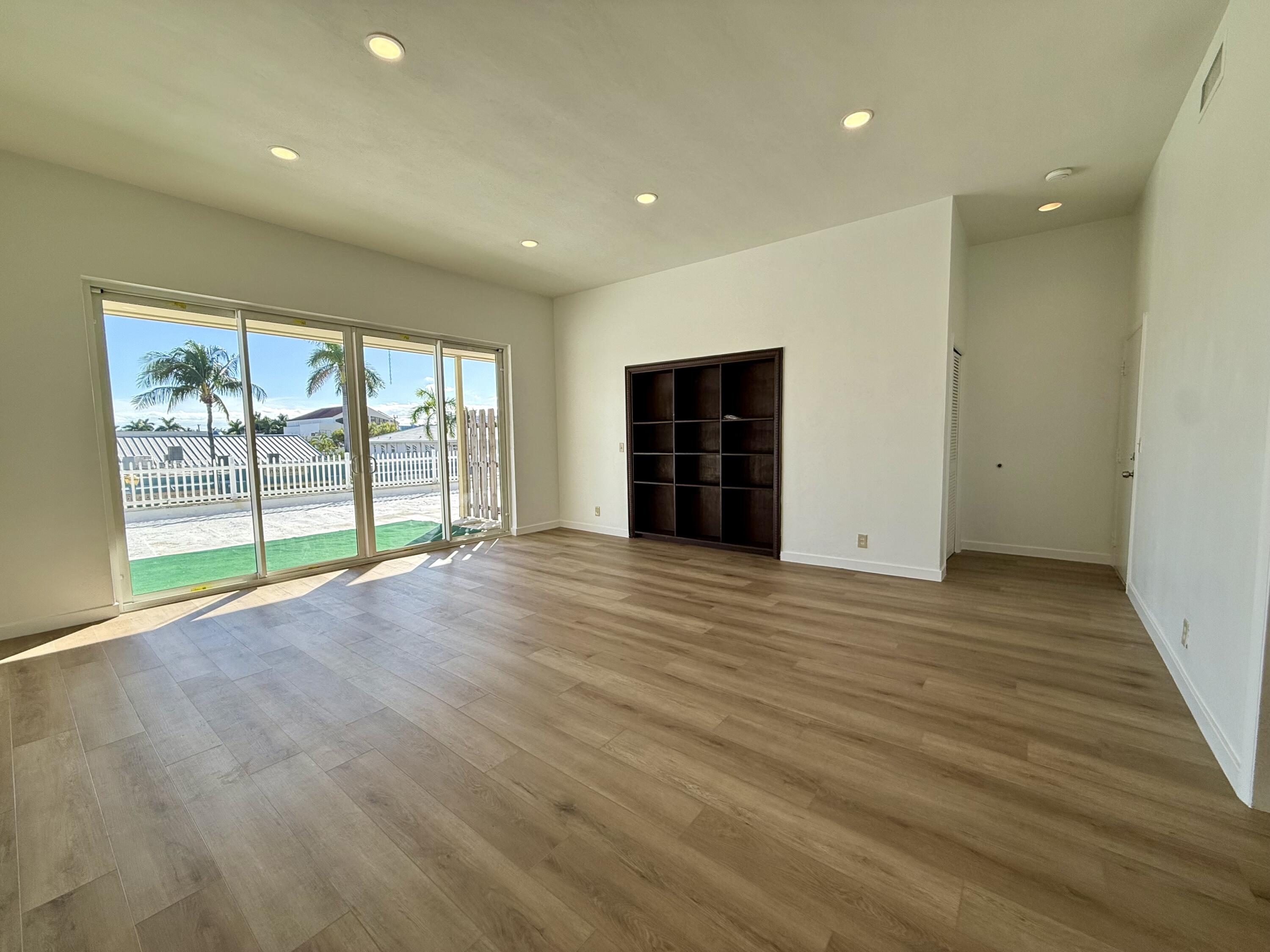 1165 East Atlantic Avenue, Unit A Delray Beach, FL 33483 - Photo 1 of 30 a view of an empty room with wooden floor and a window