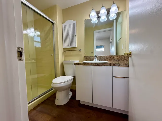 a bathroom with a sink a toilet and shower