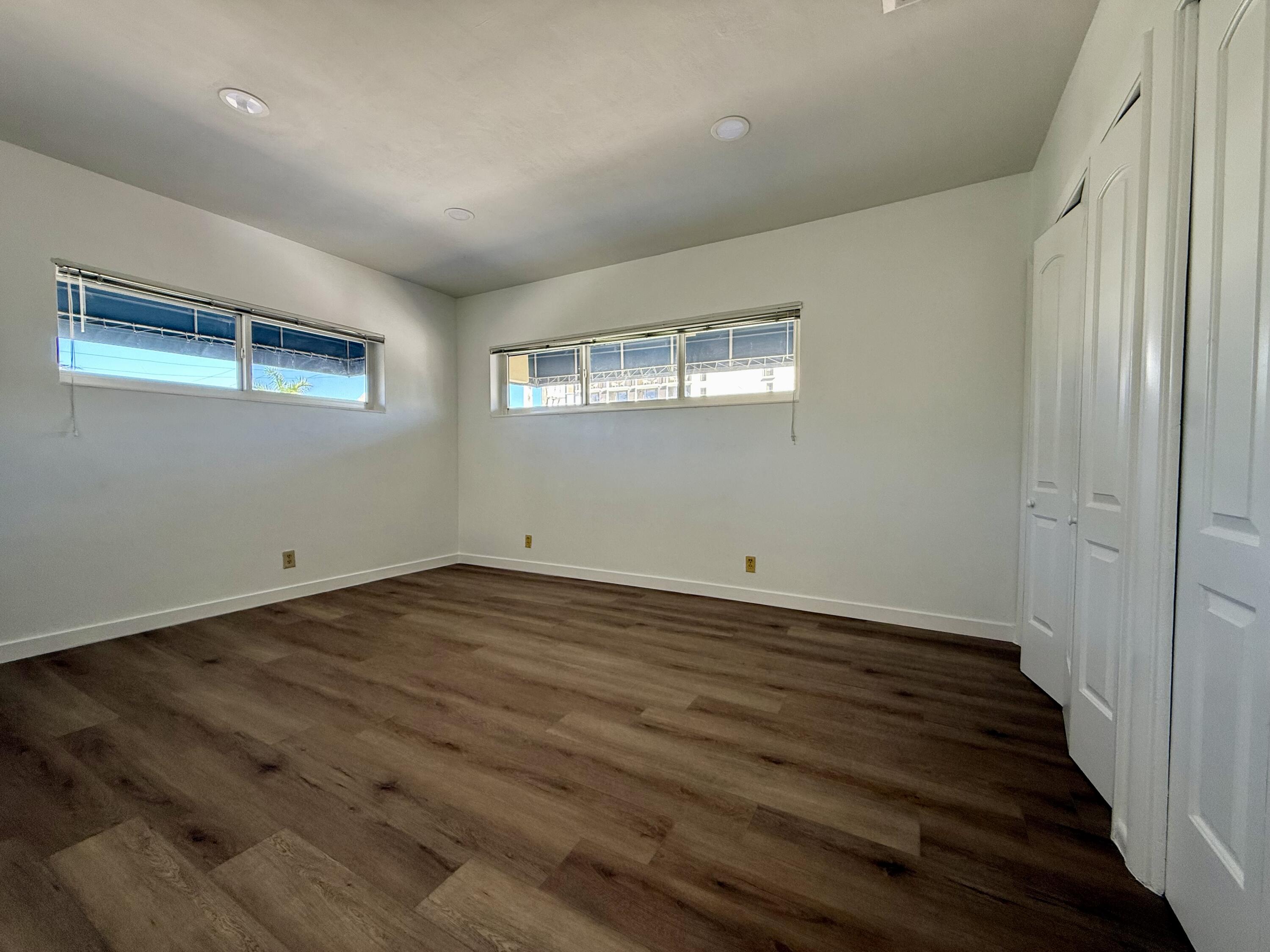 1165 East Atlantic Avenue, Unit A Delray Beach, FL 33483 - Photo 17 of 30 an empty room with wooden floor and windows