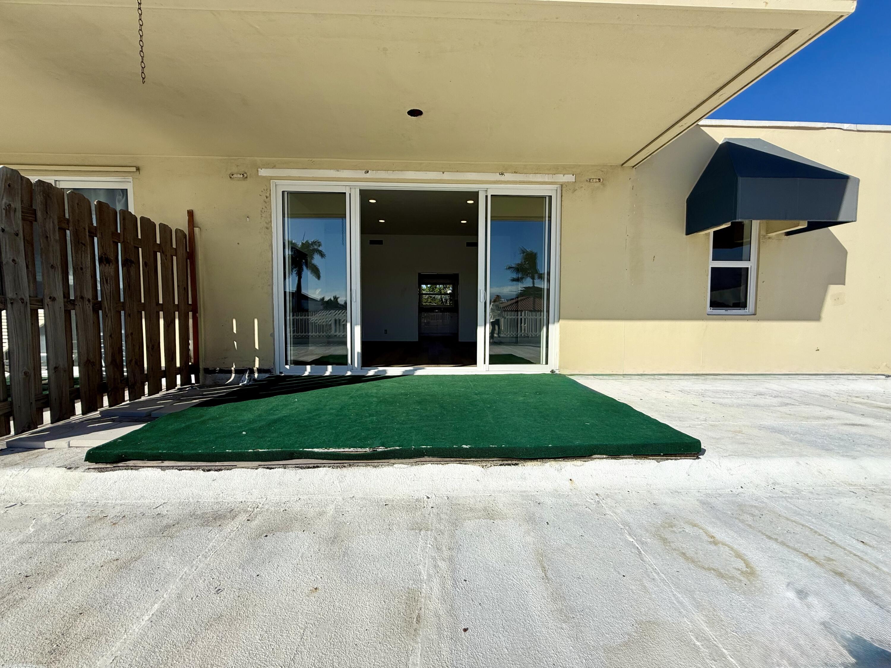 1165 East Atlantic Avenue, Unit A Delray Beach, FL 33483 - Photo 19 of 30 a front view of a house with a yard and garage