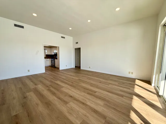 a view of empty room with wooden floor
