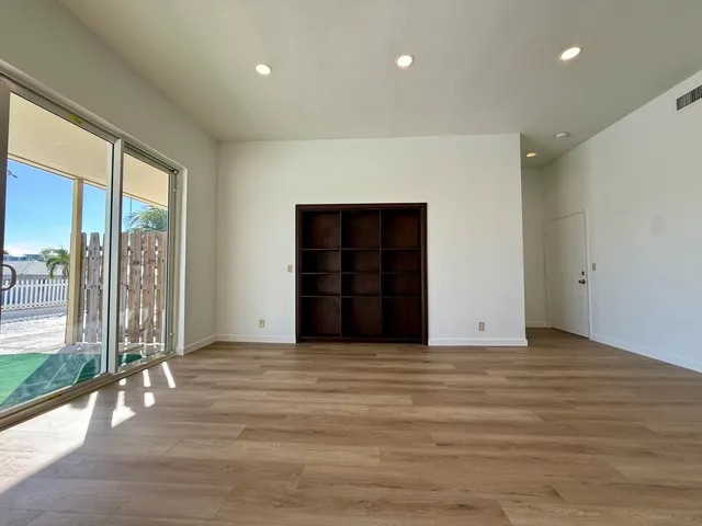 a view of an empty room with closet and entryway