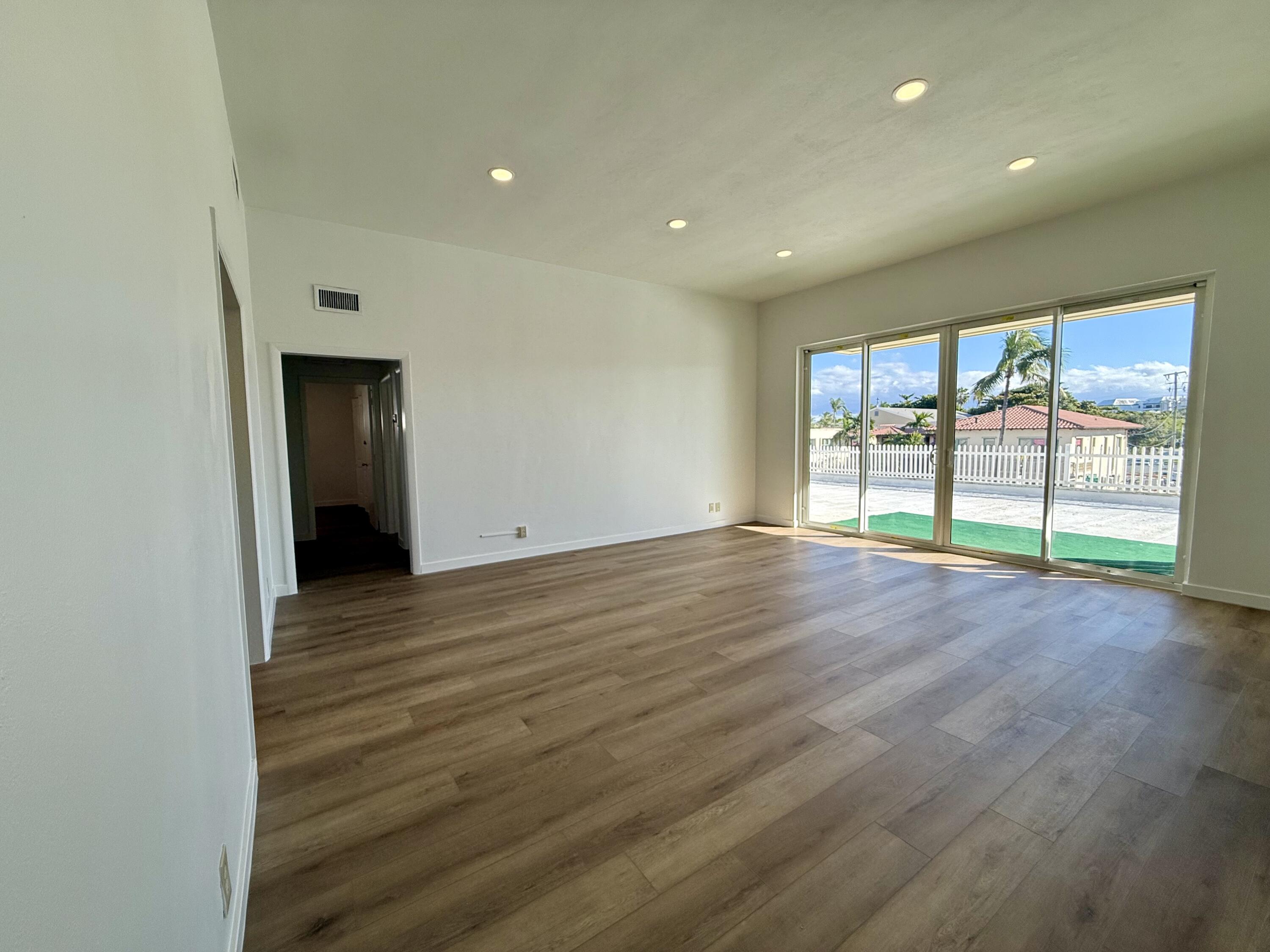 1165 East Atlantic Avenue, Unit A Delray Beach, FL 33483 - Photo 3 of 30 wooden floor in an empty room with a window
