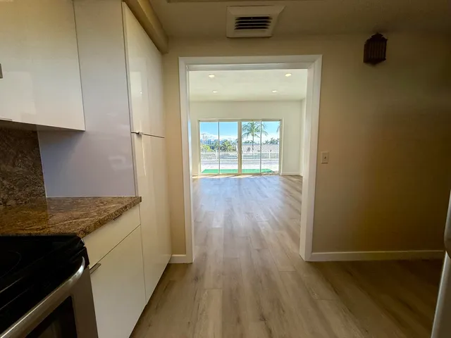 a kitchen with granite countertop white cabinets and wooden floor