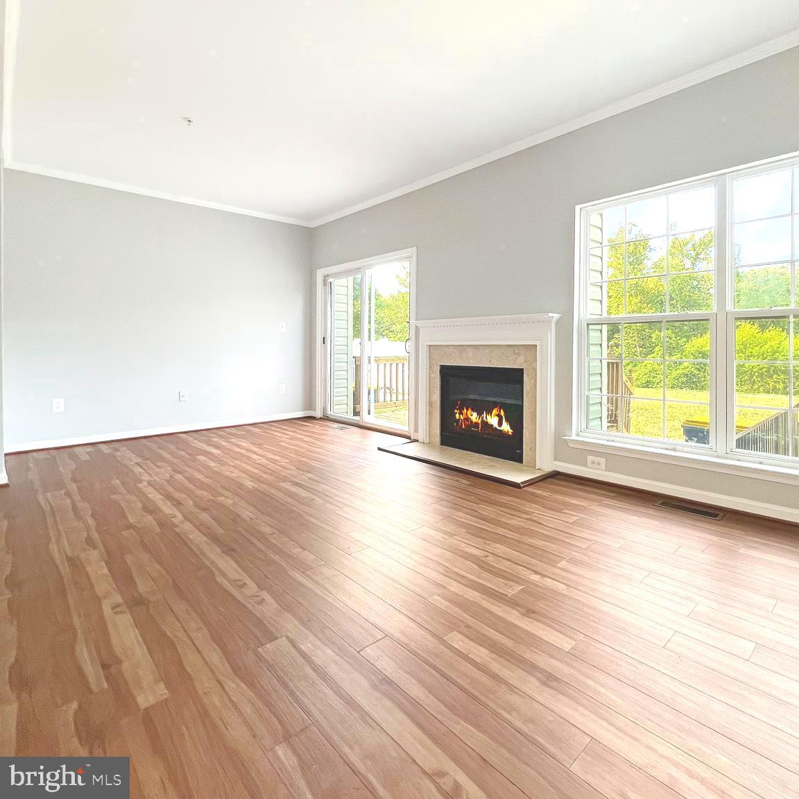 2718 Zeek Lane Lanham, MD 20706 - Photo 9 of 32 an empty room with wooden floor fireplace and windows