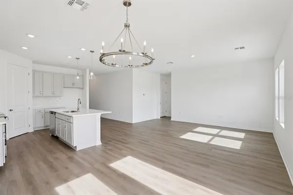 a kitchen with stainless steel appliances granite countertop a sink a counter space and wooden floor