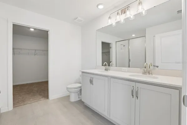 a bathroom with a double vanity sink toilet mirror and bathtub