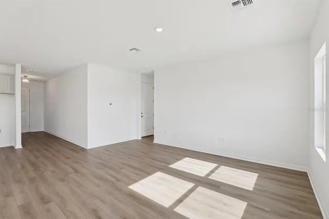 a kitchen with stainless steel appliances granite countertop a stove a sink and a refrigerator with wooden floor