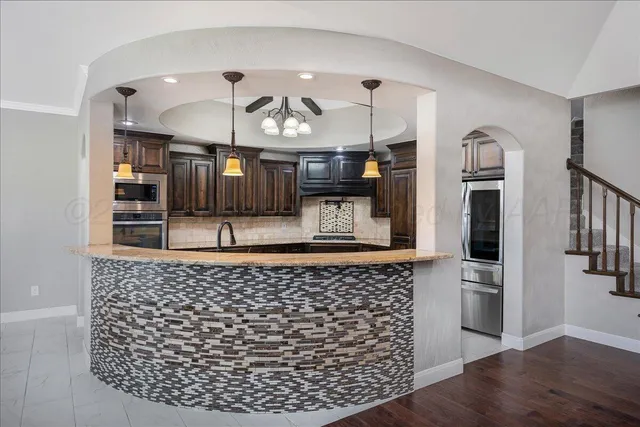 a kitchen with stainless steel appliances granite countertop wooden cabinets a sink and dishwasher