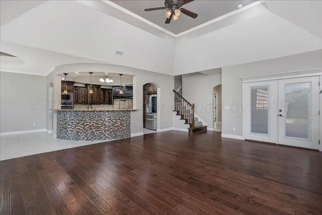 a view of a room with wooden floor and ceiling fan
