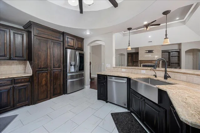 a kitchen with stainless steel appliances granite countertop a refrigerator and a sink