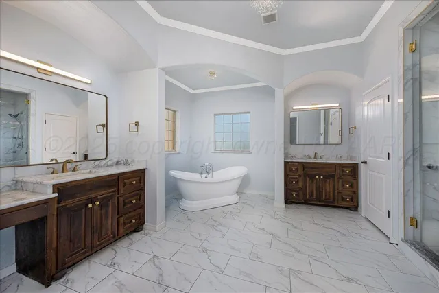 a spacious bathroom with a double vanity sink a mirror and a bathtub