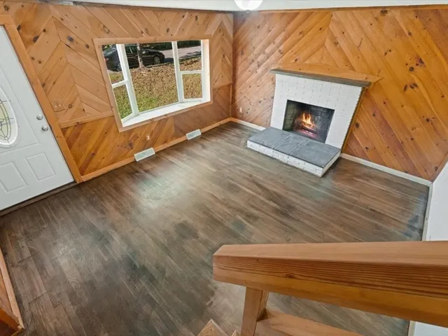 a view of a livingroom with wooden floor and a fireplace