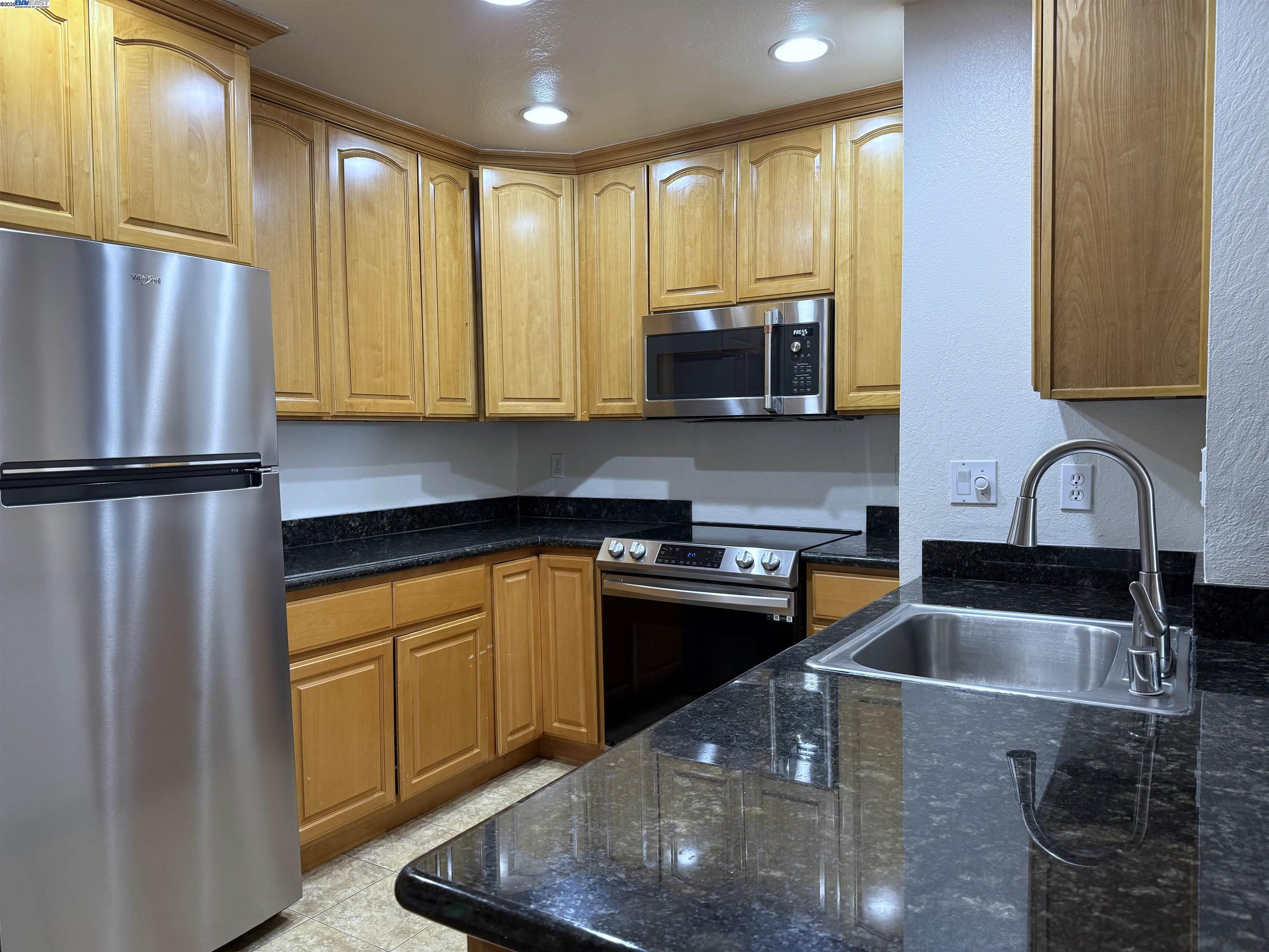 175 East Warren Common Fremont, CA 94539 - Photo 2 of 16 a kitchen with stainless steel appliances granite countertop a sink a stove and a refrigerator