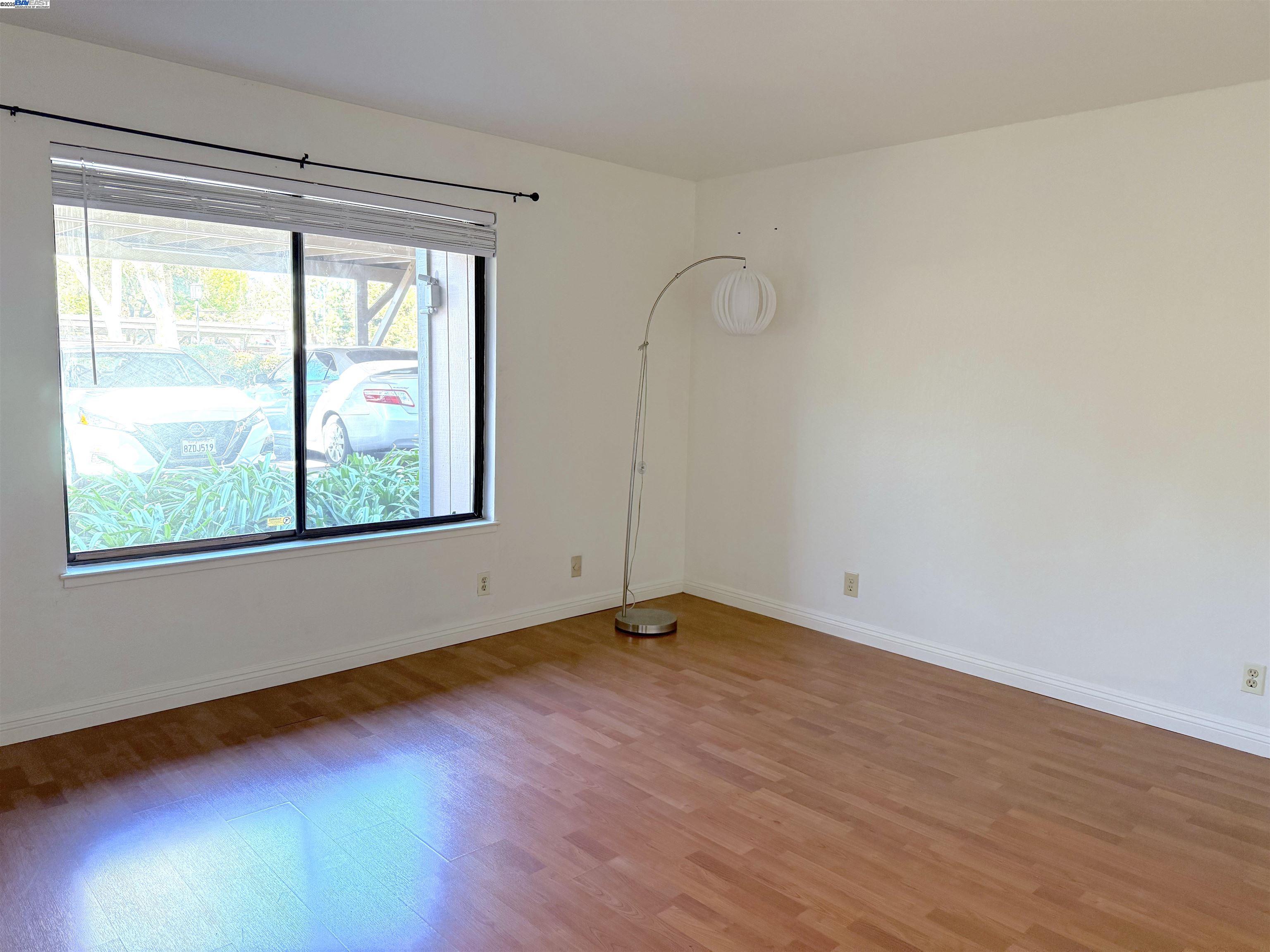 175 East Warren Common Fremont, CA 94539 - Photo 3 of 16 a view of an empty room with wooden floor and a window