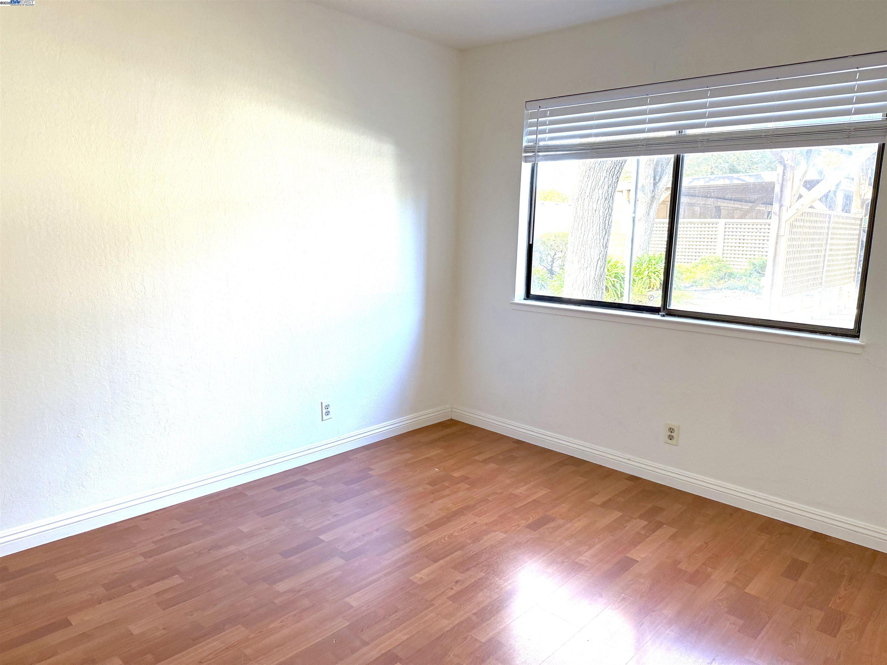 175 East Warren Common Fremont, CA 94539 - Photo 5 of 16 an empty room with wooden floor and windows
