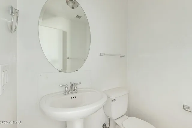 a bathroom with a toilet a sink and mirror