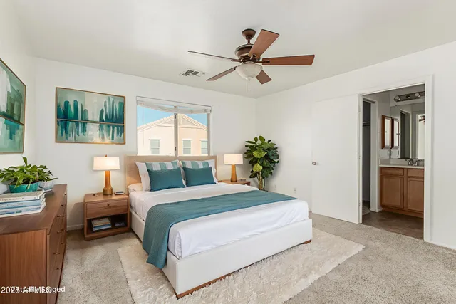 a bedroom with a large bed and a chandelier