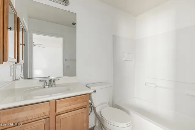 a bathroom with a granite countertop sink a toilet and a mirror