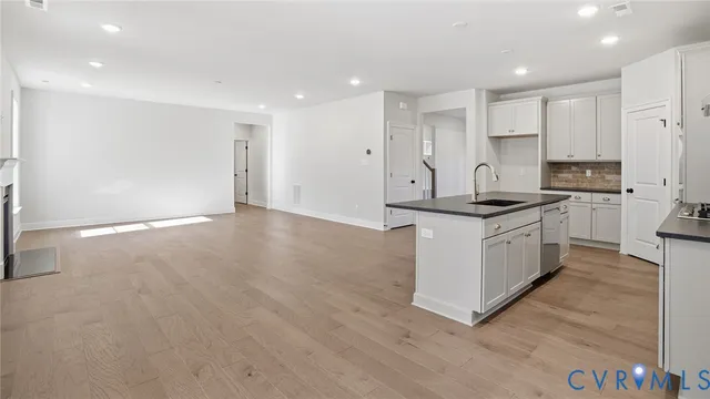 a kitchen that has a lot of white cabinets and stainless steel appliances