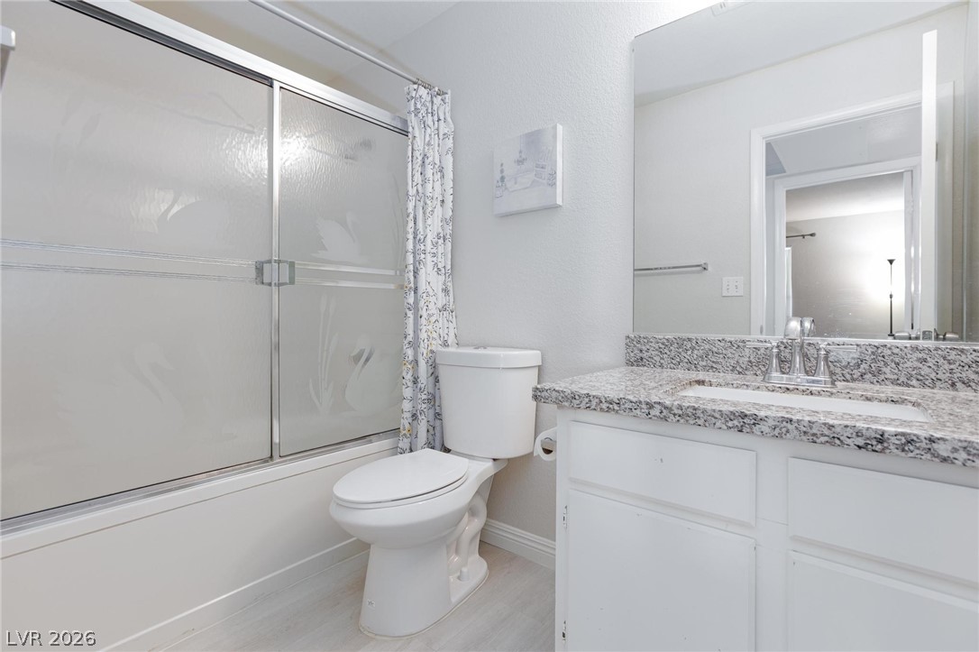 5171 South Lindell Road, Unit 103 Las Vegas, NV 89118 - Photo 17 of 24 Modern bath with granite counters, sleek white cabinetry, and shower-tub combination.