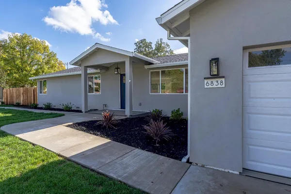 a backyard of a house with table and chairs