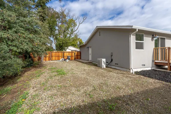 a view of a house with backyard and trees