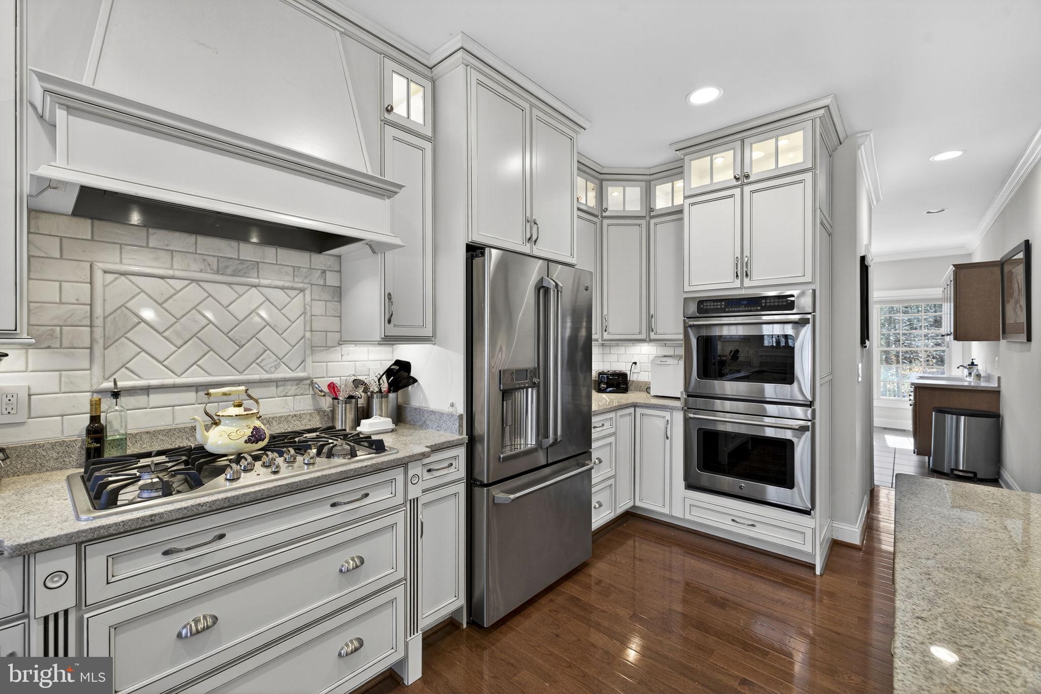 8485 Rogues Road Warrenton, VA 20187 - Photo 15 of 121 a kitchen with granite countertop a refrigerator and a stove top oven