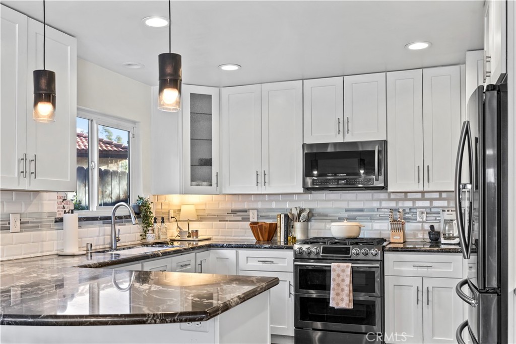 28046 Millar Street Highland, CA 92346 - Photo 12 of 39 a kitchen with stainless steel appliances granite countertop a sink a stove and a refrigerator