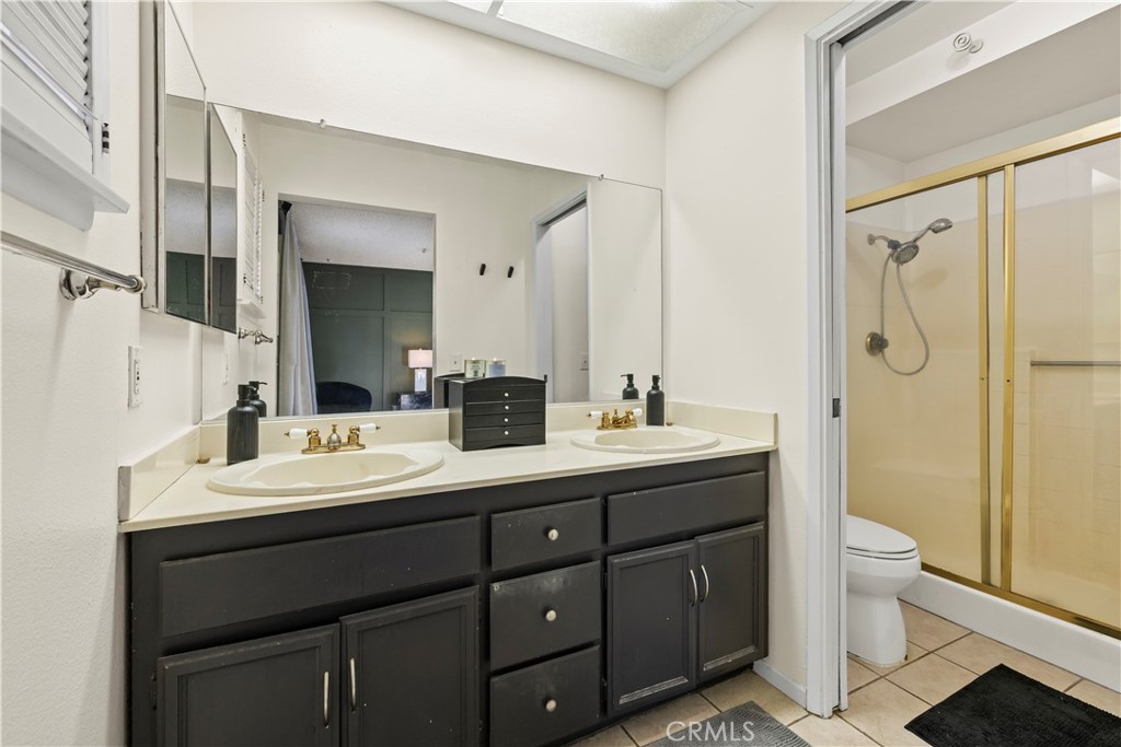 28046 Millar Street Highland, CA 92346 - Photo 32 of 39 a bathroom with a double vanity sink toilet mirror and shower