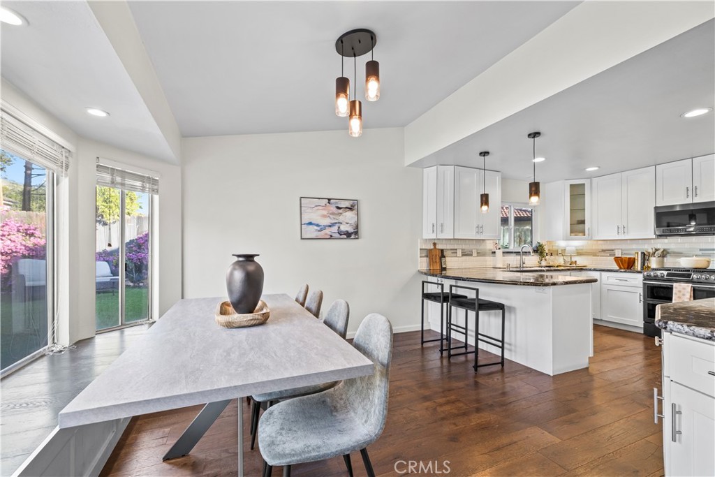 28046 Millar Street Highland, CA 92346 - Photo 9 of 39 a kitchen with a table chairs refrigerator and microwave
