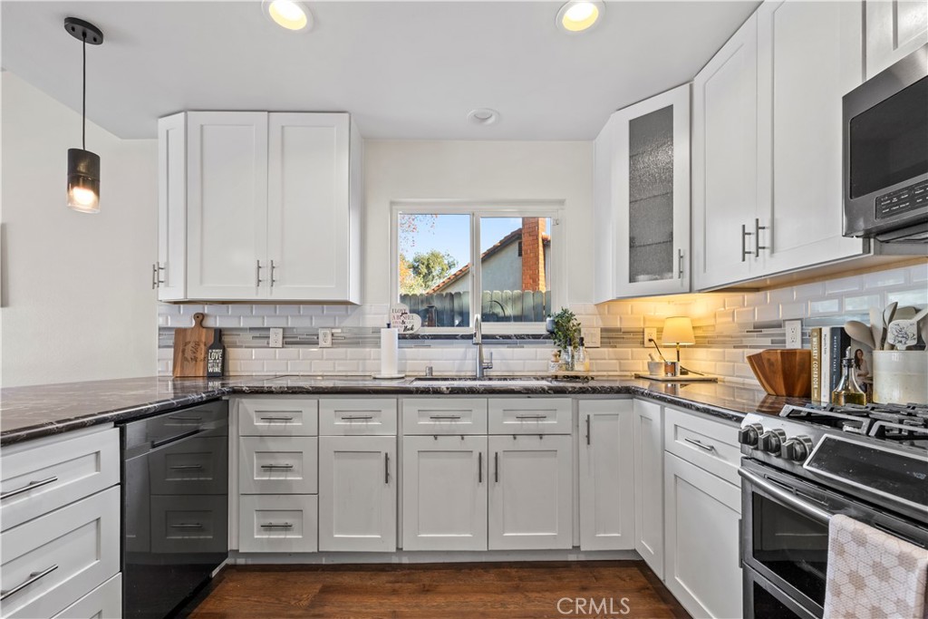 28046 Millar Street Highland, CA 92346 - Photo 10 of 39 a kitchen with granite countertop a sink stainless steel appliances and cabinets