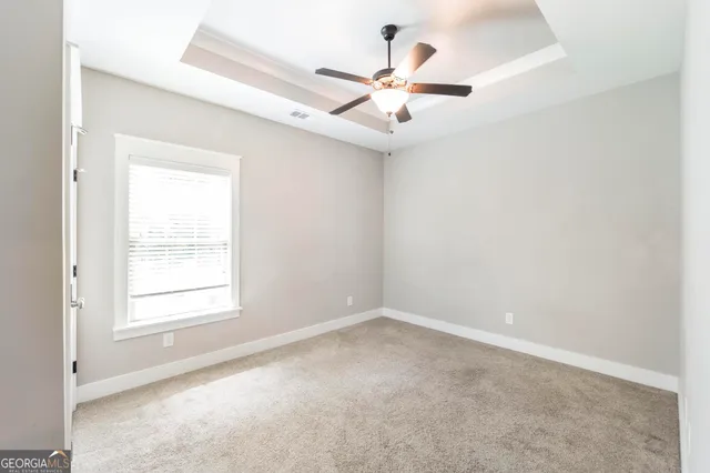 an empty room with chandelier fan