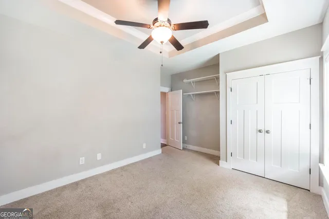 a view of an empty room with wooden floor and iron stairs