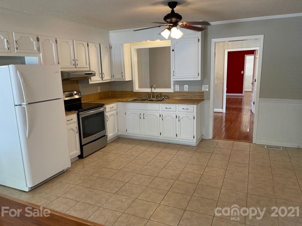129 Loray Farm Road Dallas, NC 28034 - Photo 11 of 28 a kitchen with granite countertop a stove a sink and a refrigerator