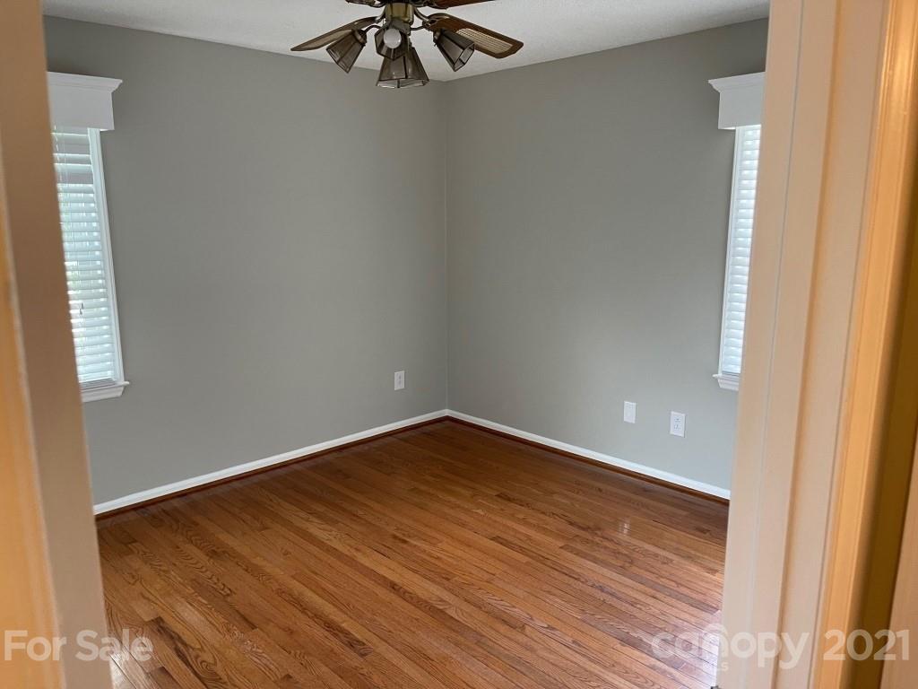 129 Loray Farm Road Dallas, NC 28034 - Photo 26 of 28 an empty room with a ceiling fan and wooden floor