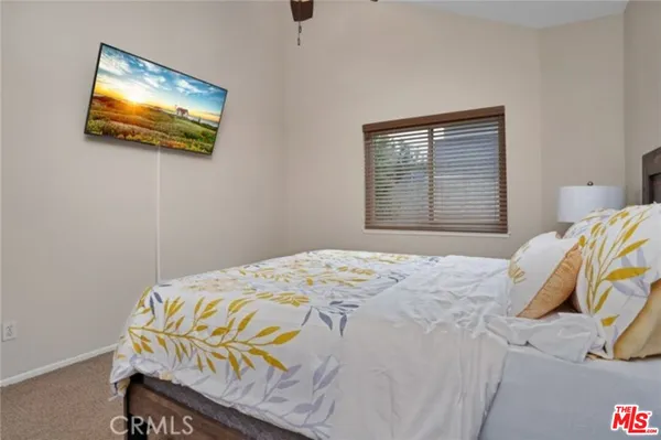a bedroom with a bed and a painting on the wall