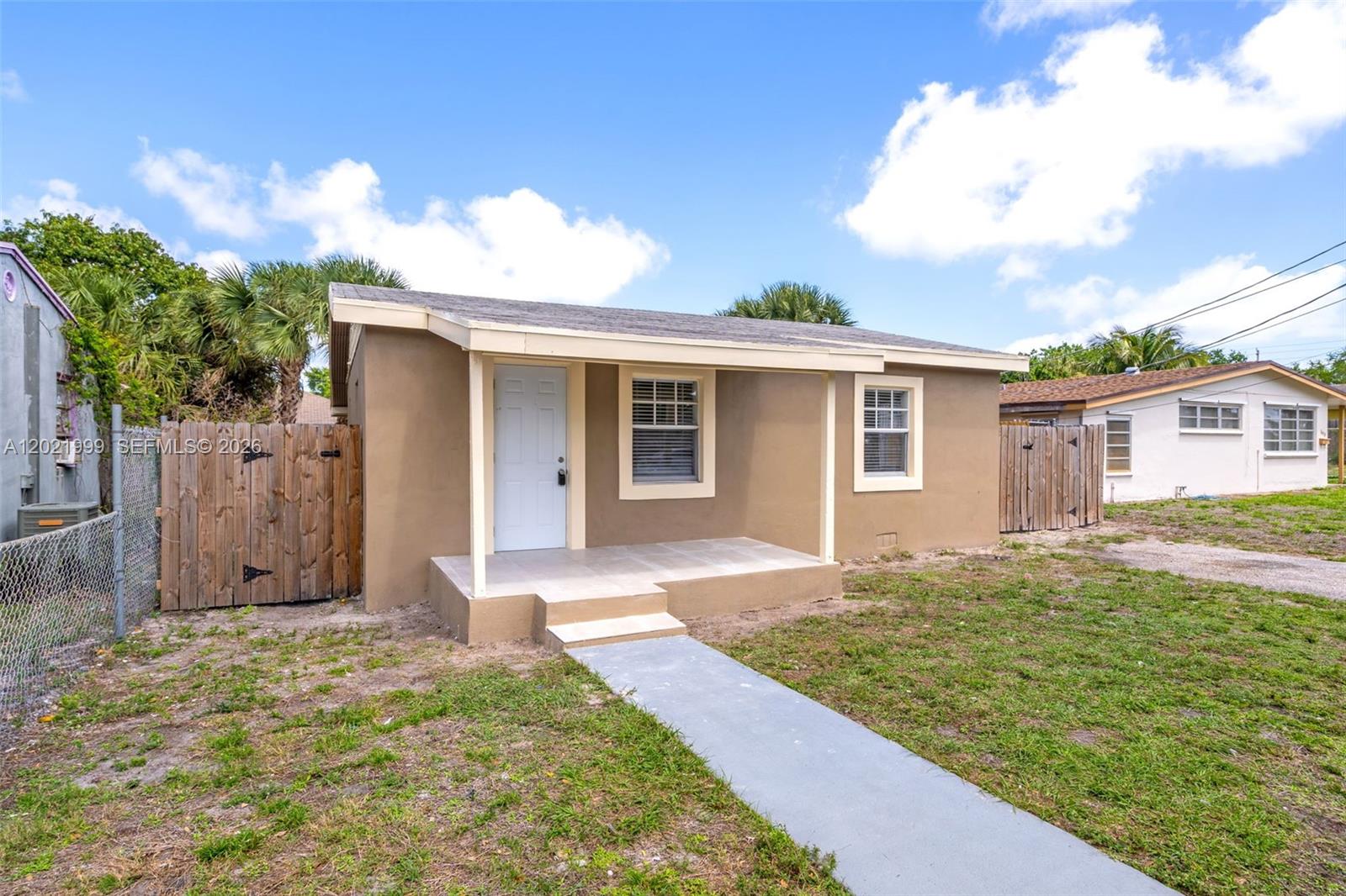 1660 West 26th Street Riviera Beach, FL 33404 - Photo 3 of 28 a front view of a house with garden