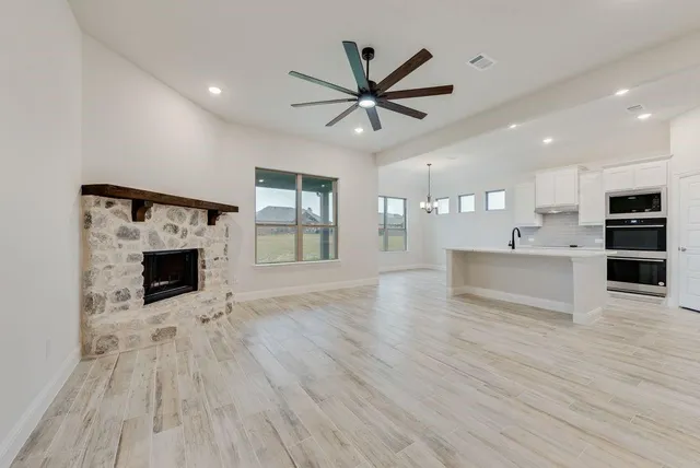 a view of an empty room with a fireplace and window