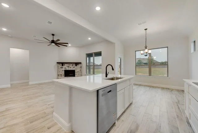 a view of a kitchen with a sink wooden floor and a living room