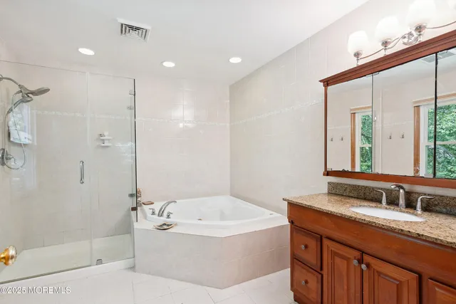 a bathroom with a granite countertop tub sink shower and mirror